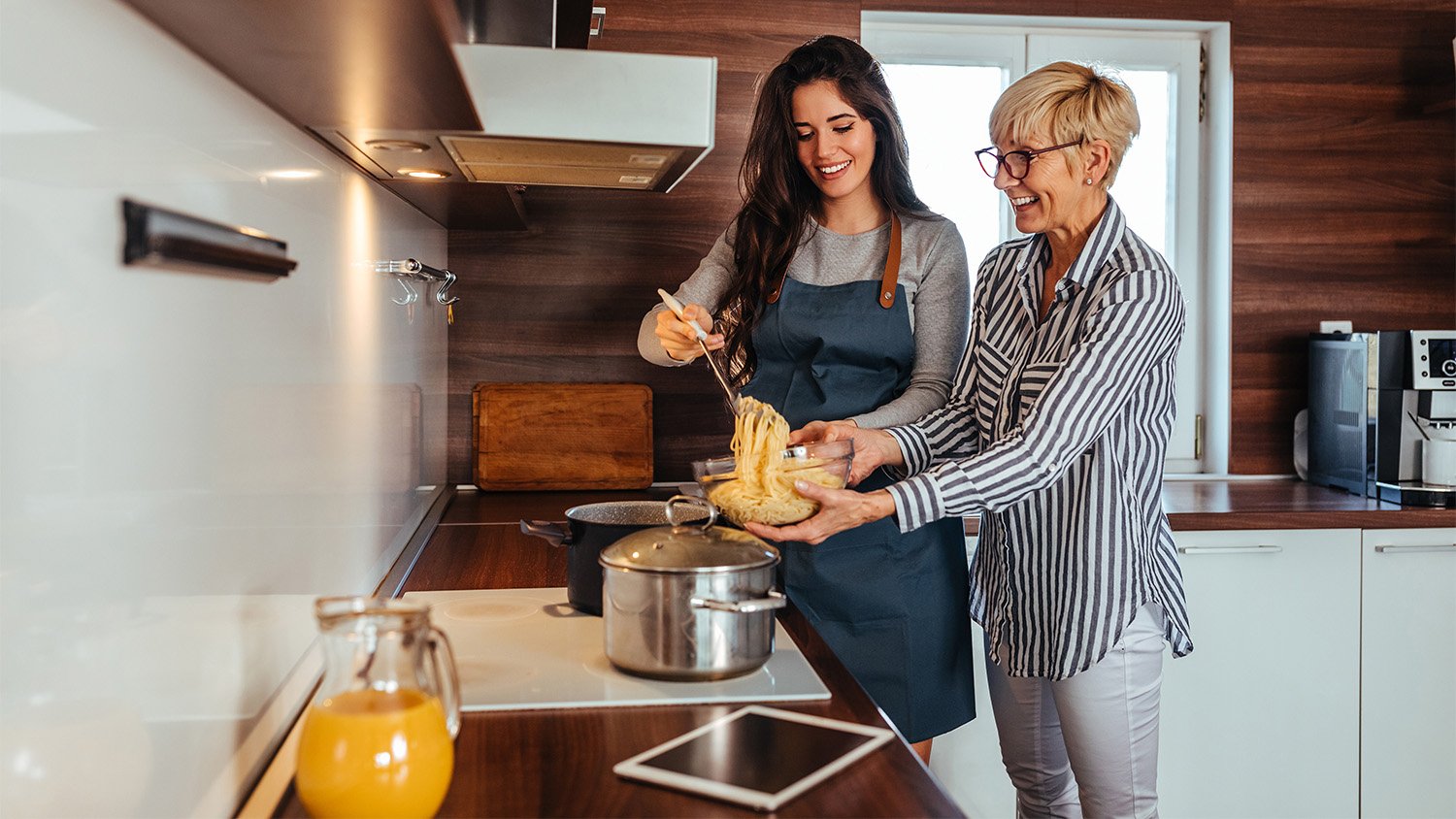 older mother and daughter cooking together     